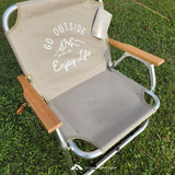 Camping chair with 'Go Outside, Captain Stag, Enjoy Life' text on a grass background