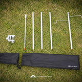 Lalipha camping pole set laid out on green grass, including four white poles, a white ground anchor, a black carrying bag, and a black strap, with the Lalipha logo visible on the bag.