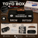 Toyo Box Field Coffee Kit shown as a black metal carrying case with a brown handle, alongside its retail box and an included accessories layout on a dark wood background. Text highlights 'Genuine Toyo Box' and 'Made in Japan'.